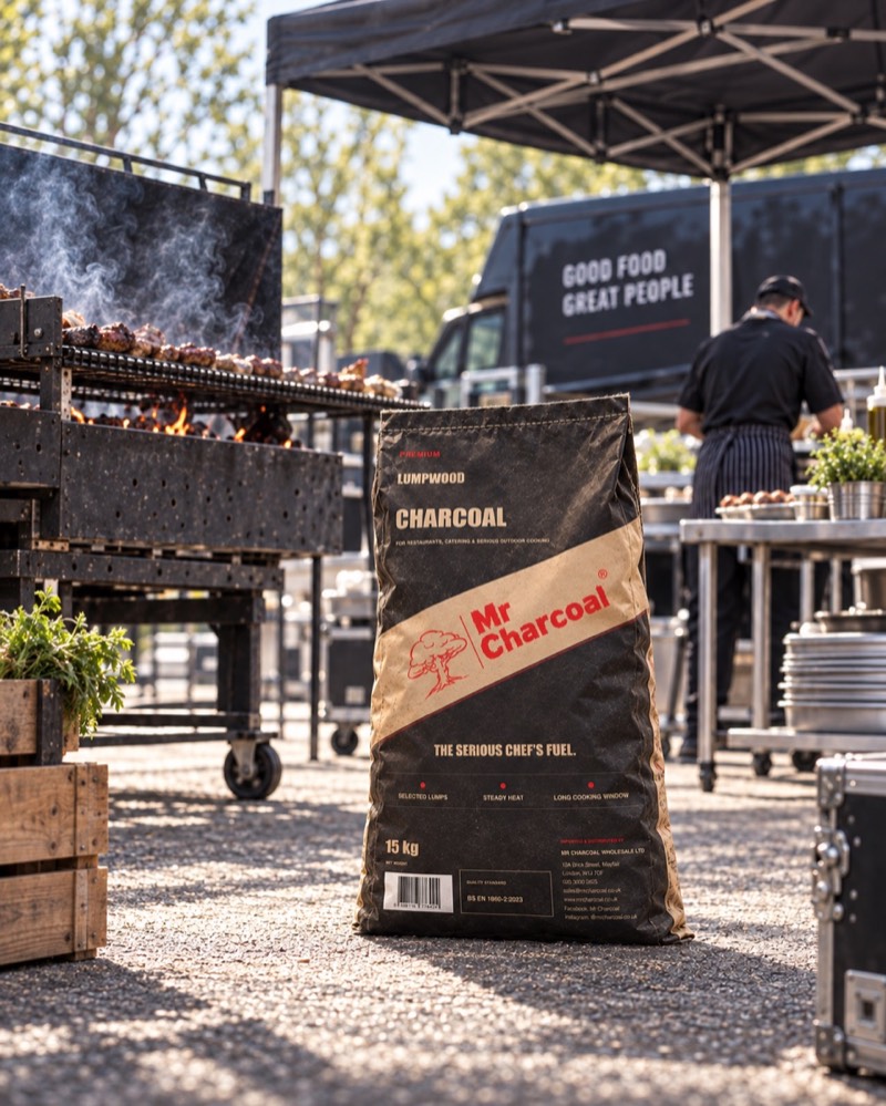 Mr Charcoal bag in an outdoor catering setting with a charcoal grill and food van